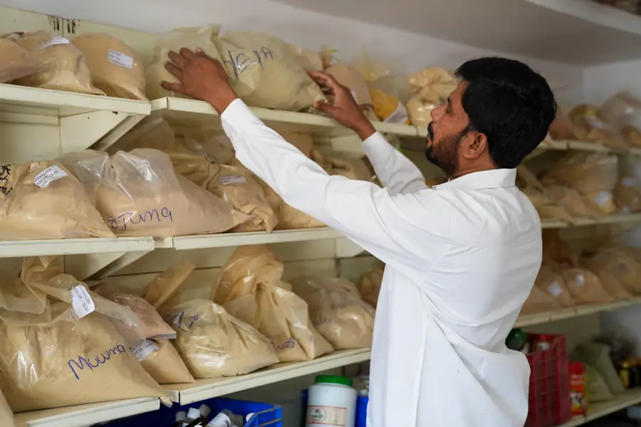 Hand-labelled bags of herbal powders on the dispensary shelves